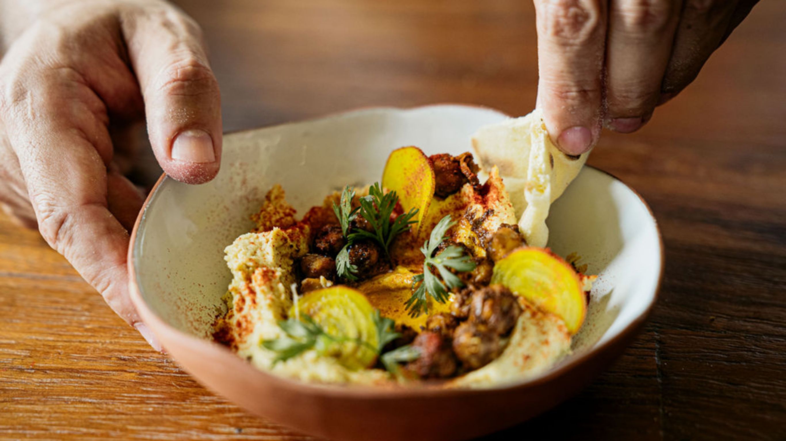 Platillo de hummus colorido del menú de almuerzo de Zapote Bar 